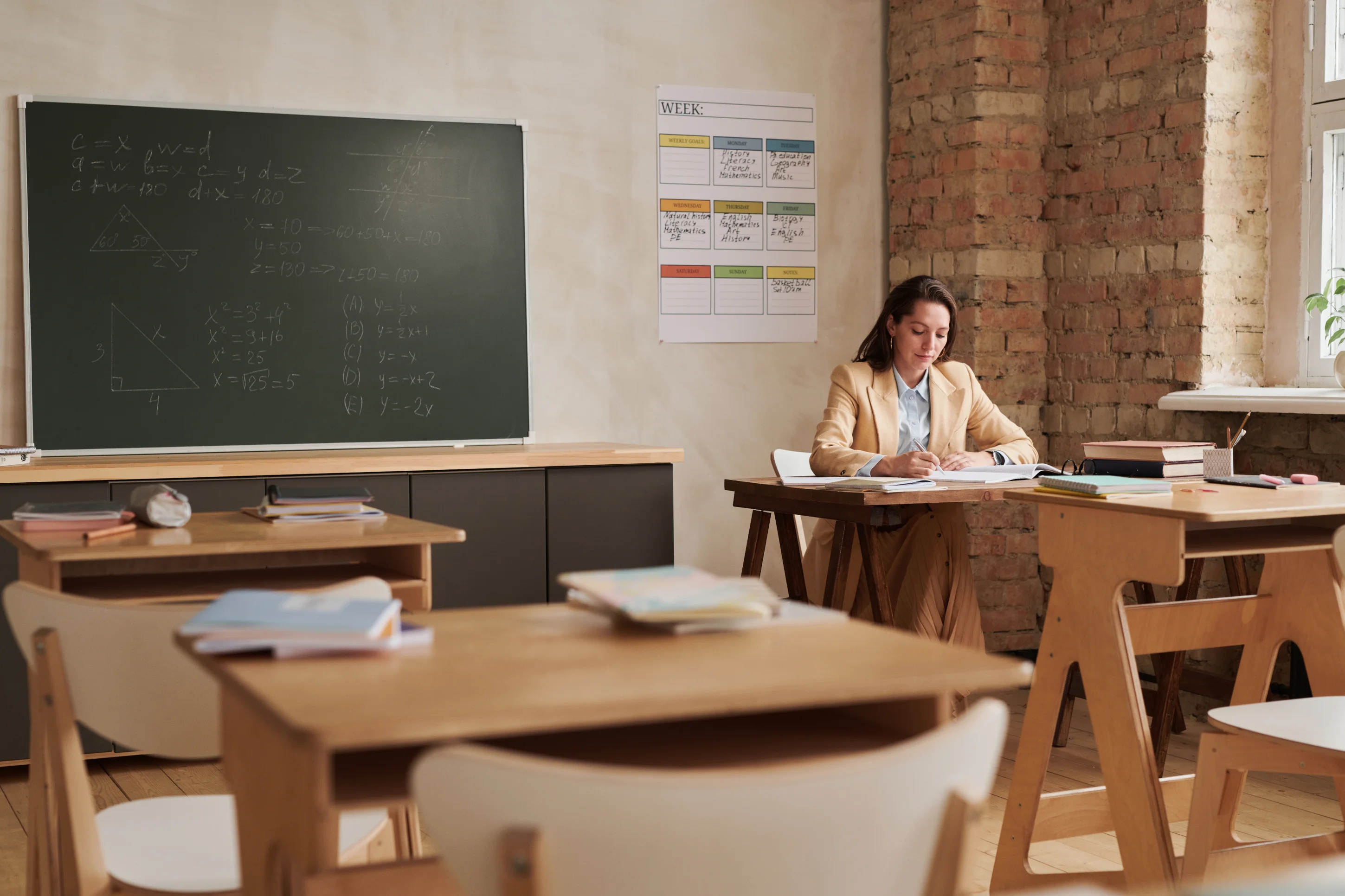 teacher sitting on desk writing quick 50 general report card comments